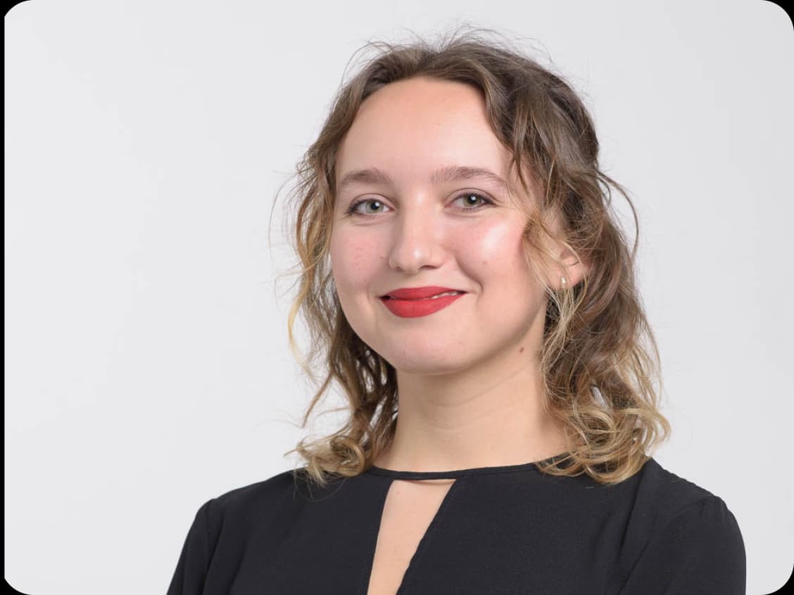 Frau strahlt in die Kamera nach beruflichem Erfolg durch das Female Hiring Programm von socialbee